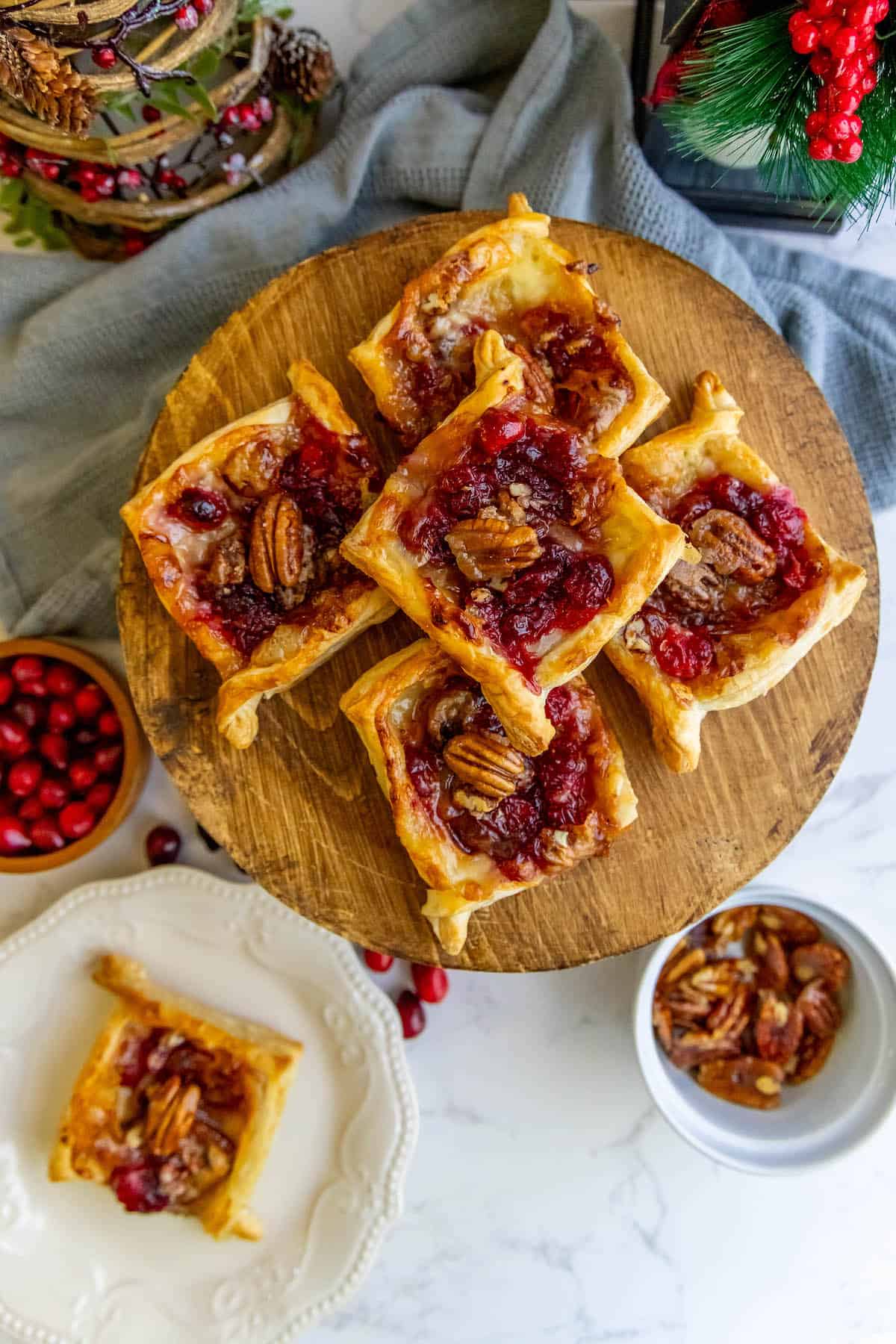 Cranberry pecan tarts and cranberries on a plate.
