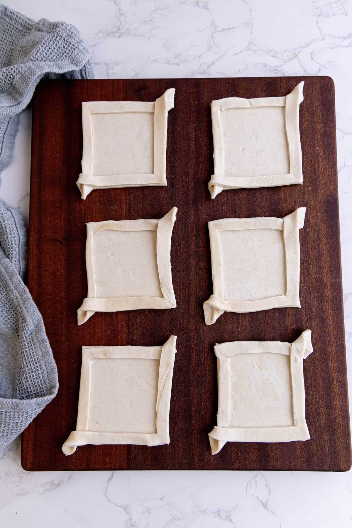 Four cranberry brie bites on a cutting board.