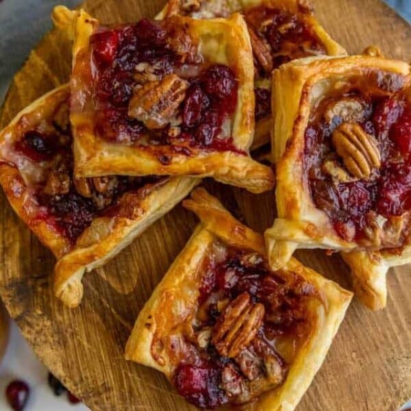 Cranberry pecan tarts on a wooden plate.