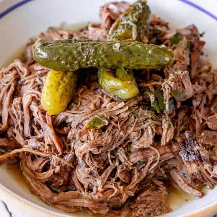 A bowl of pulled pork with pickles
