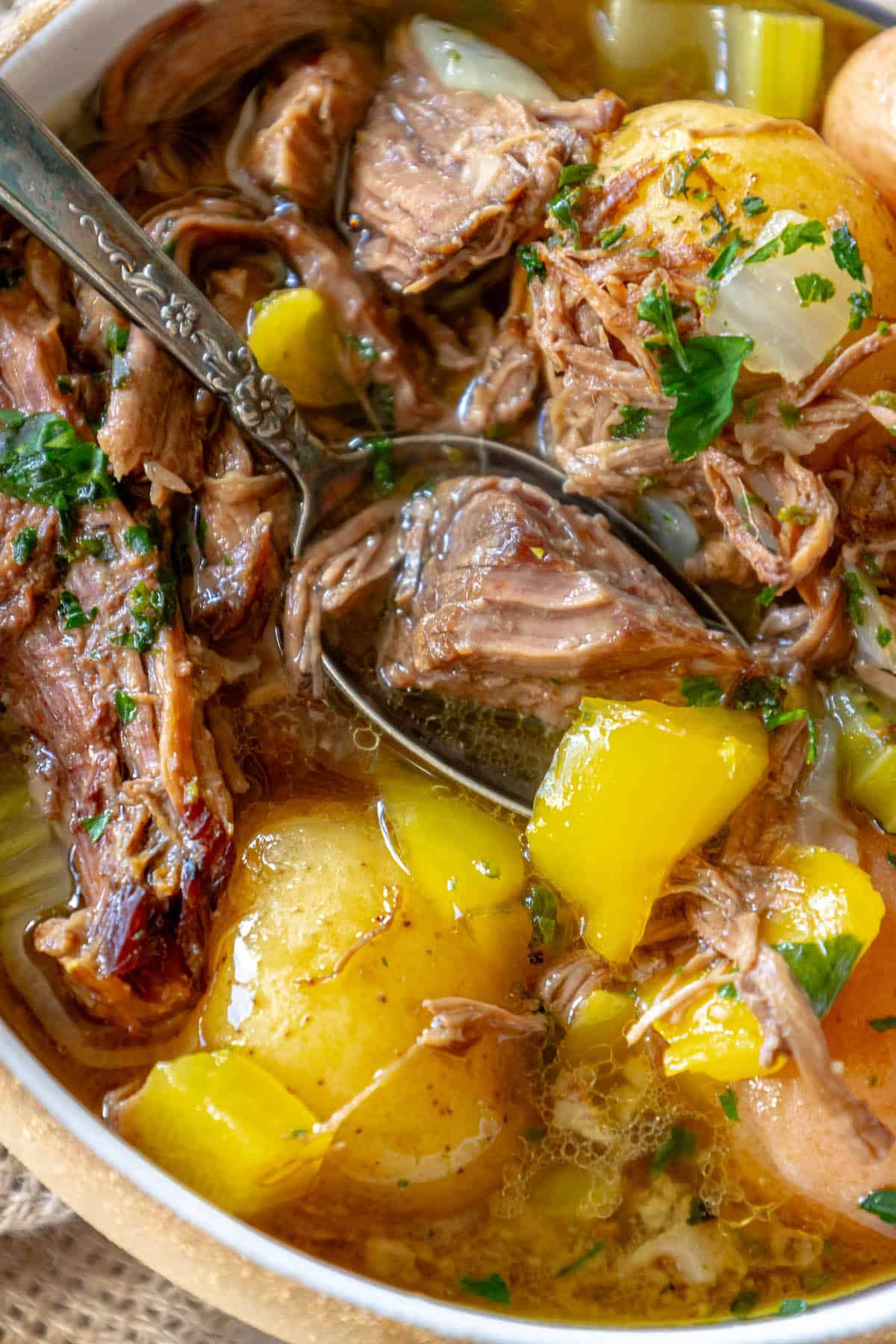 A bowl of pot roast stew with meat and potatoes.