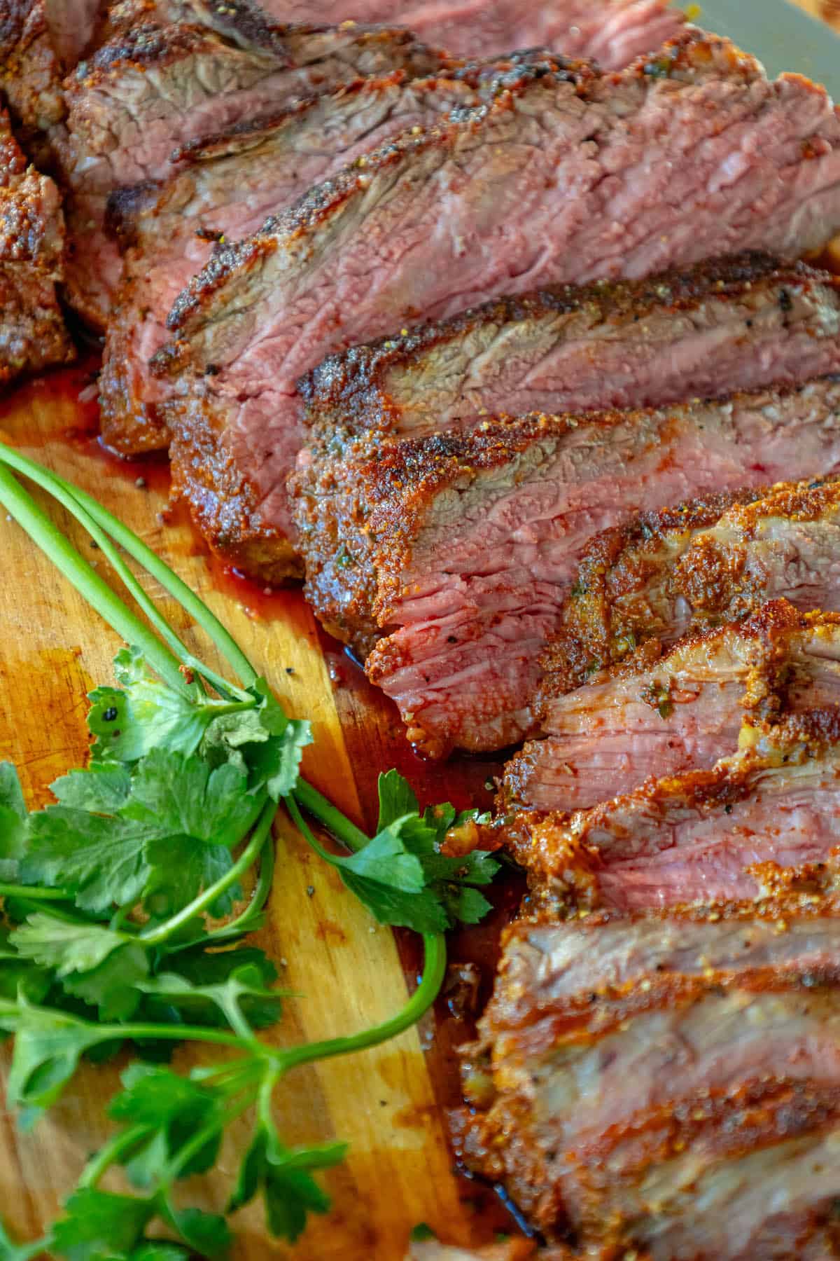 A reverse seared tri-tip steak resting on a cutting board.