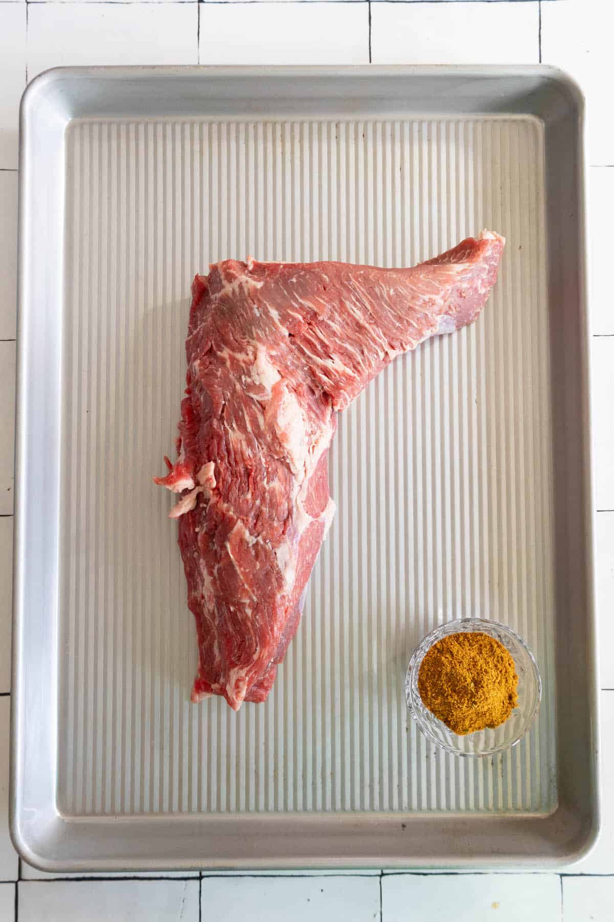 A reverse seared tri-tip steak on a baking sheet.