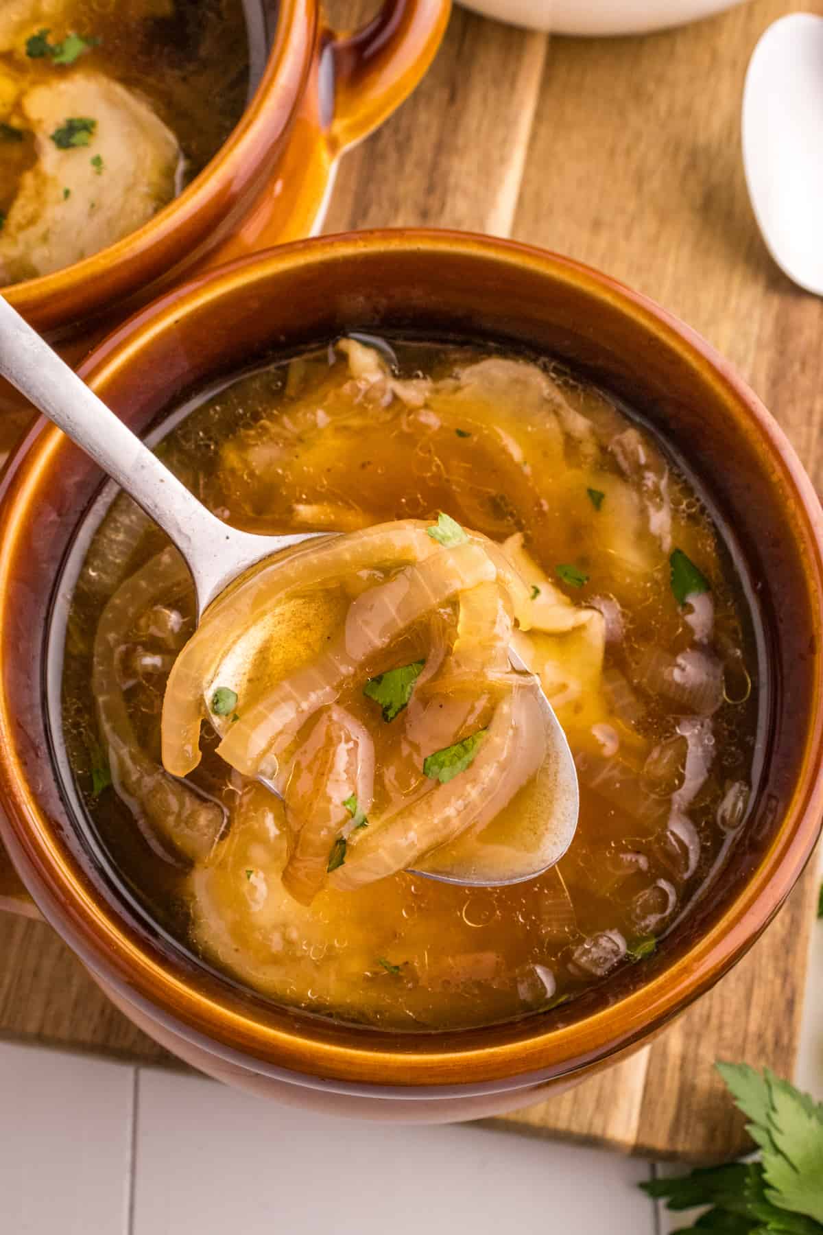 The Best French Onion Soup Recipe, a delicious bowl of soup with onions and parsley.