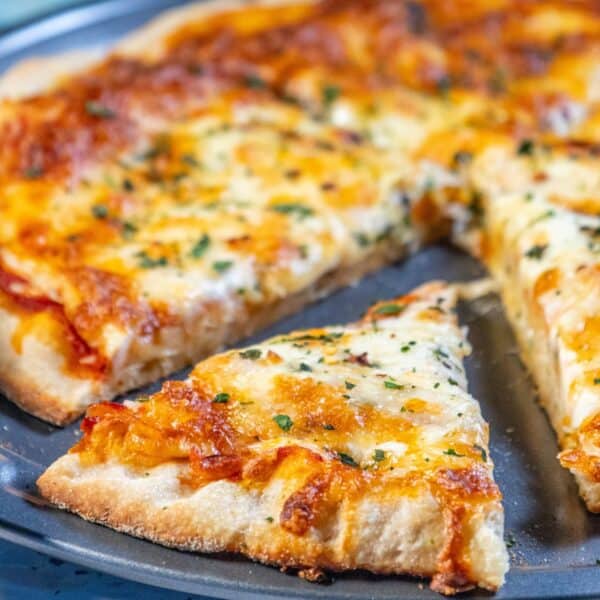 An easy homemade pizza with cheese and herbs on a plate.