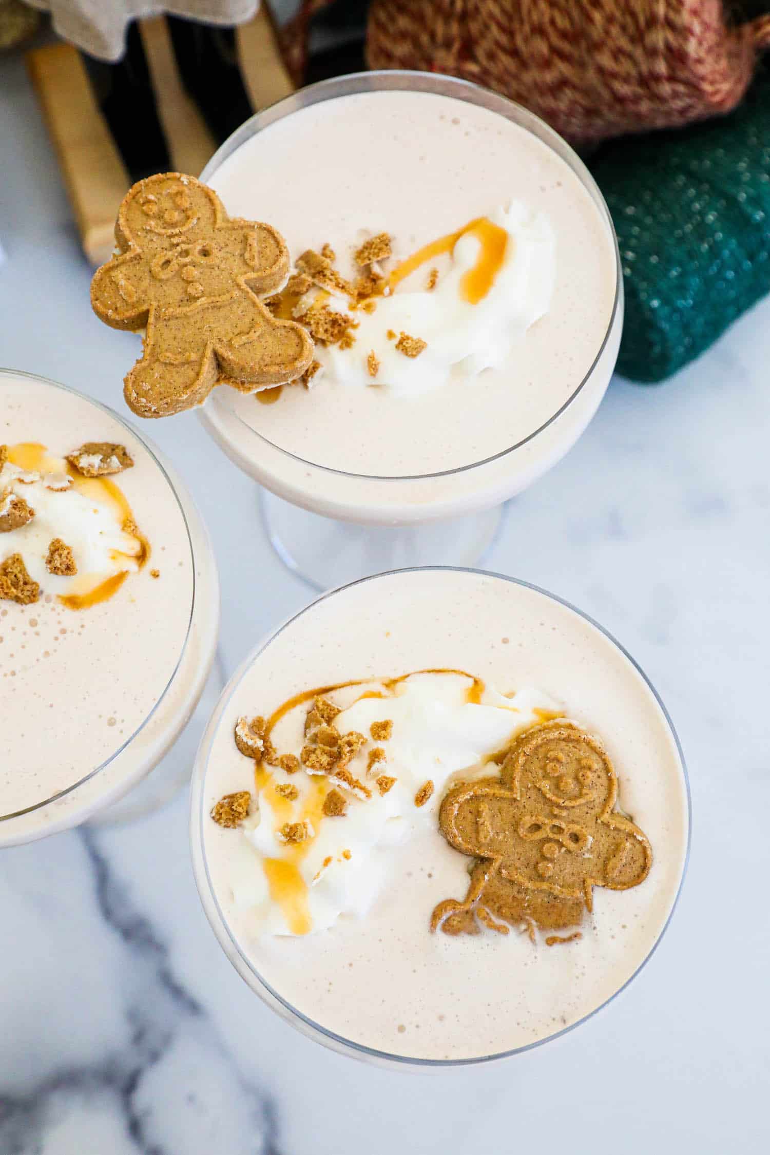 Indulge in a delightful gingerbread martini garnished with a dollop of whipped cream and accompanied by delectable gingerbread cookies.