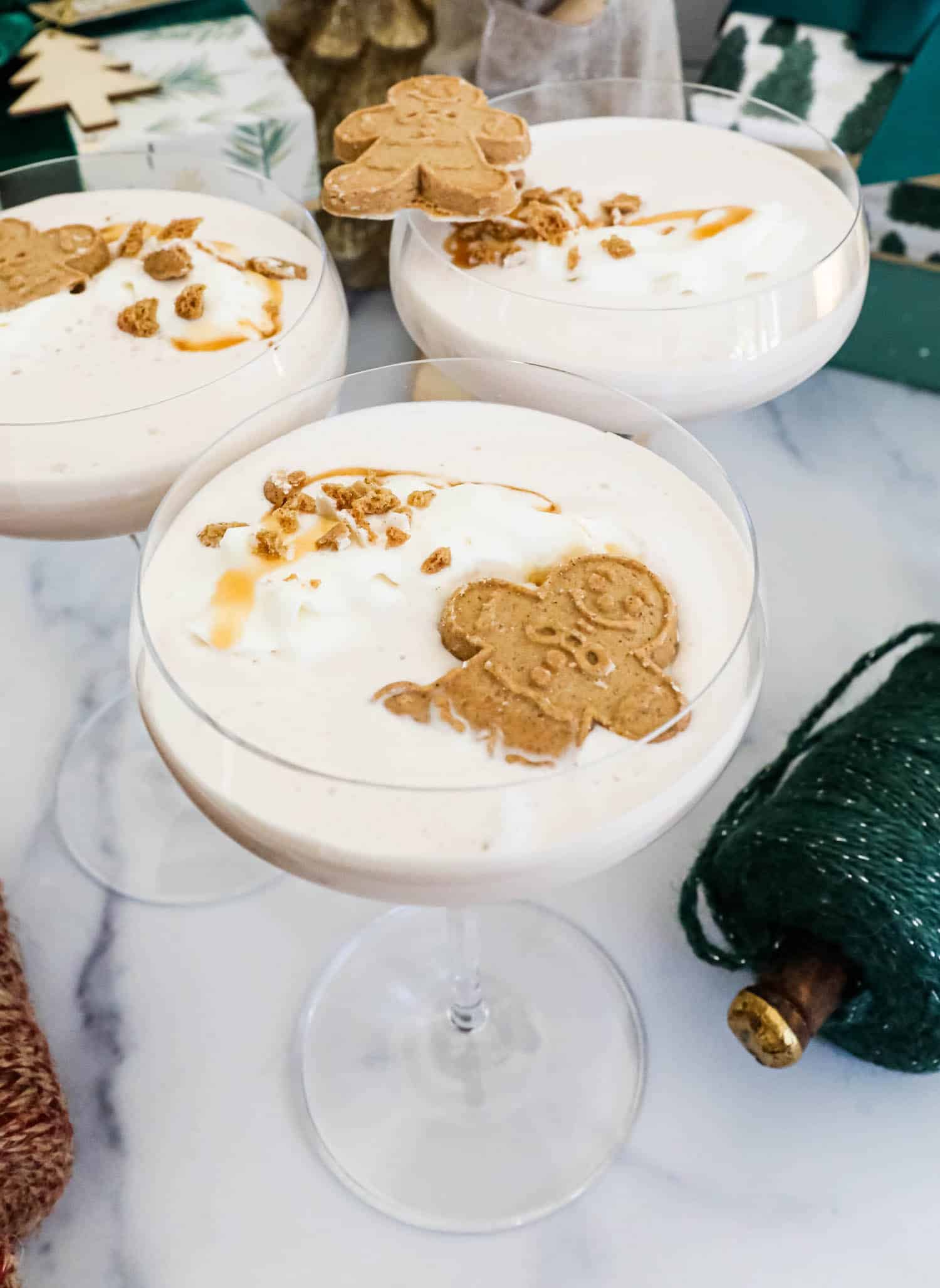 Gingerbread martini garnished with whipped cream and gingerbread cookies.