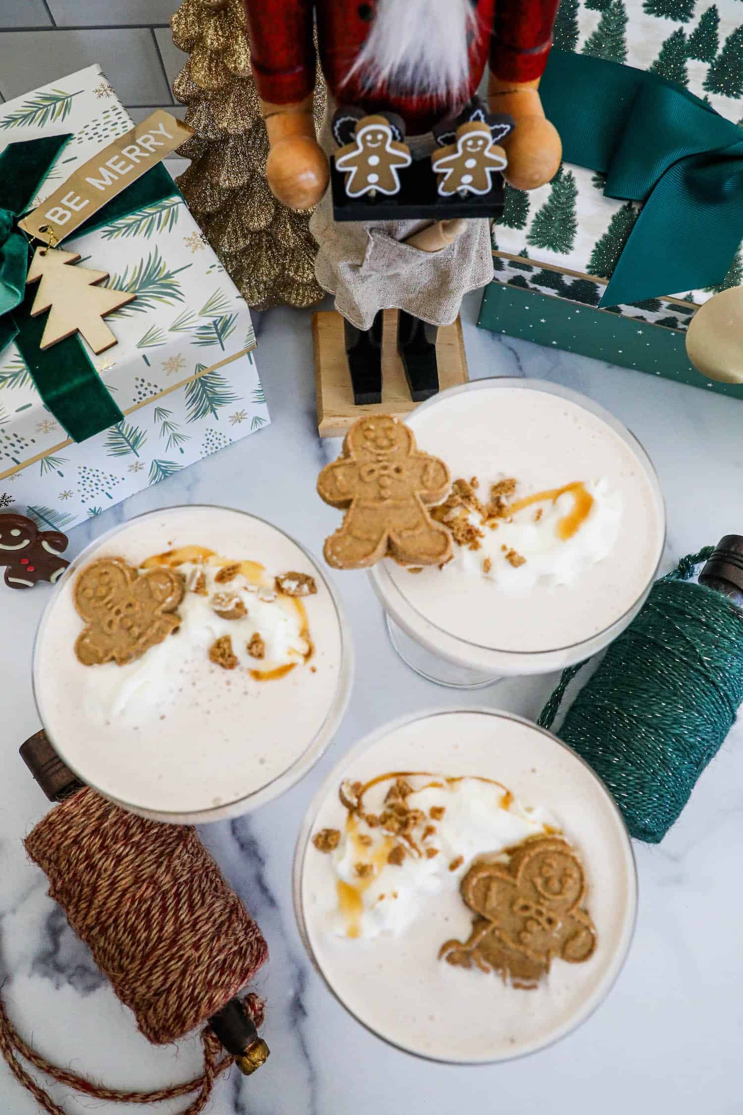 Gingerbread latte with whipped cream and gingerbread cookies atop a gingerbread martini.