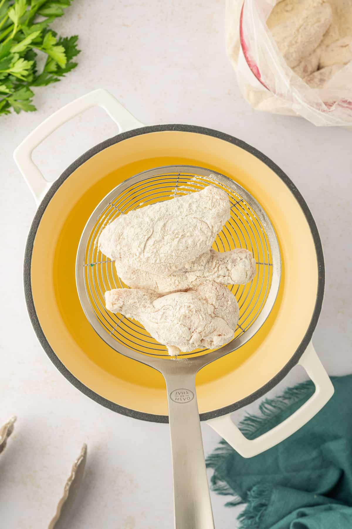 A yellow frying pan with chicken wings in it, seasoned with lemon pepper.