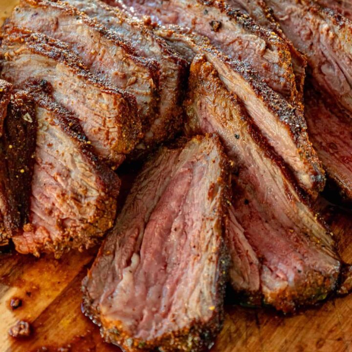 Tri tip steak sliced on a cutting board.
