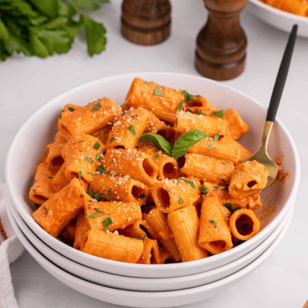 A spicy bowl of rigatoni pasta with sauce, parmesan cheese, and a kick.