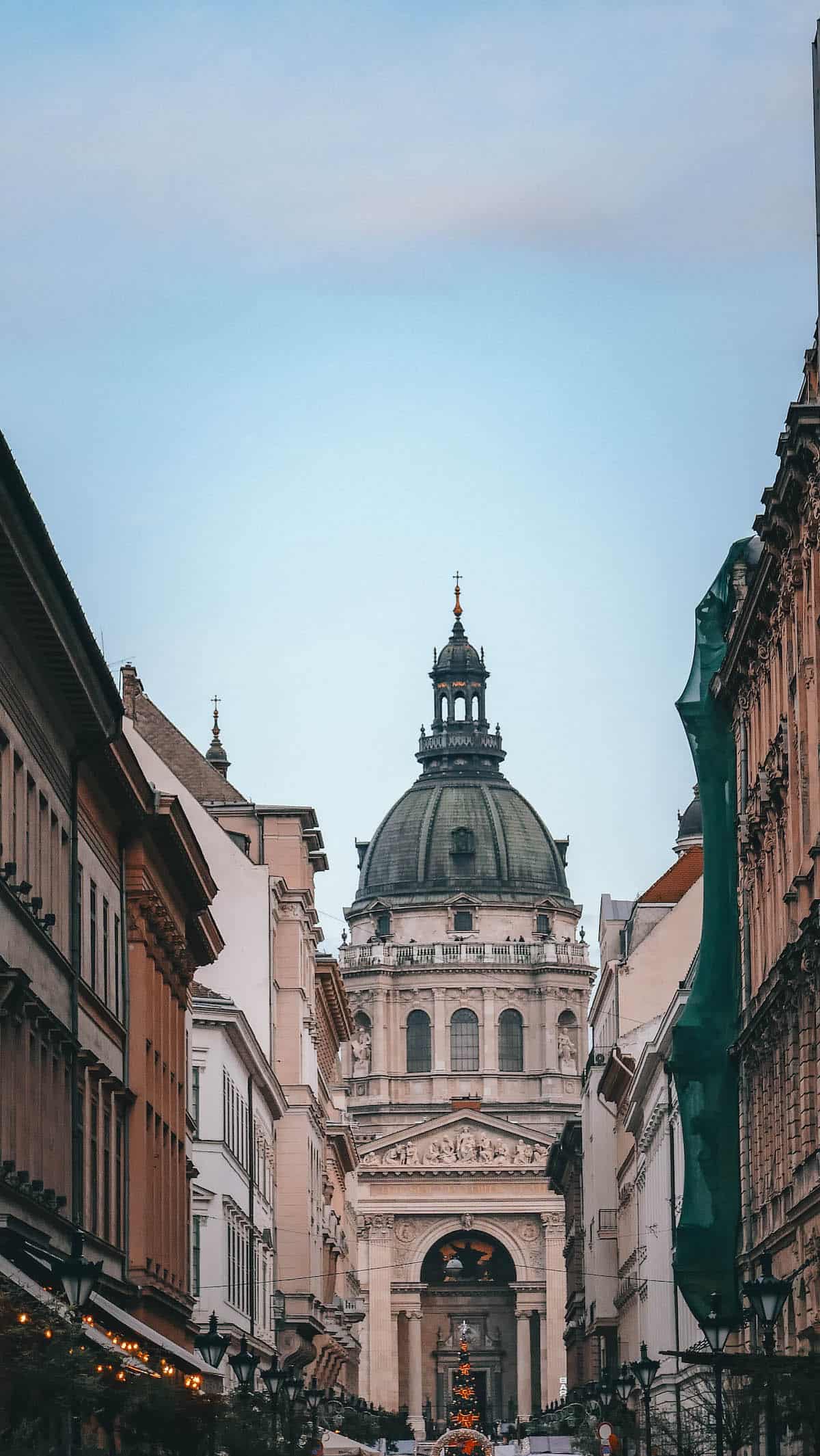 The Definitive Hungarian Goulash 20 A charming street in Budapest, lined with historical buildings and featuring a grand dome, capturing the city's architectural beauty.