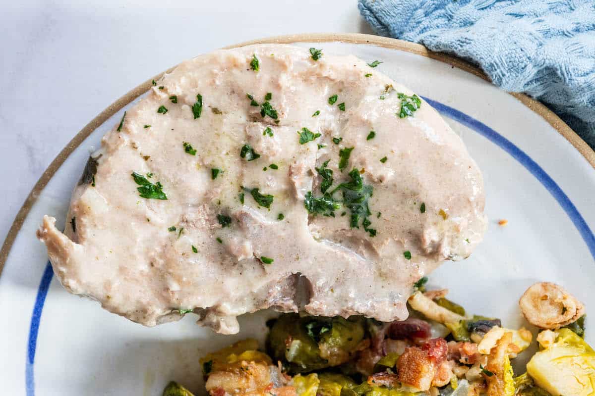 Creamy ranch pork tenderloin with brussels sprouts on a plate.