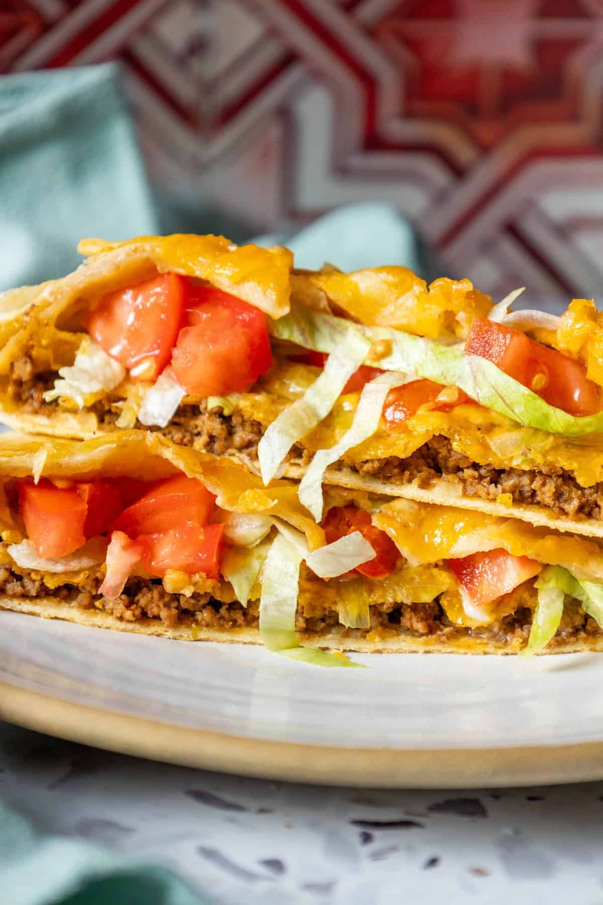 Two homemade quesadillas are stacked on a plate.