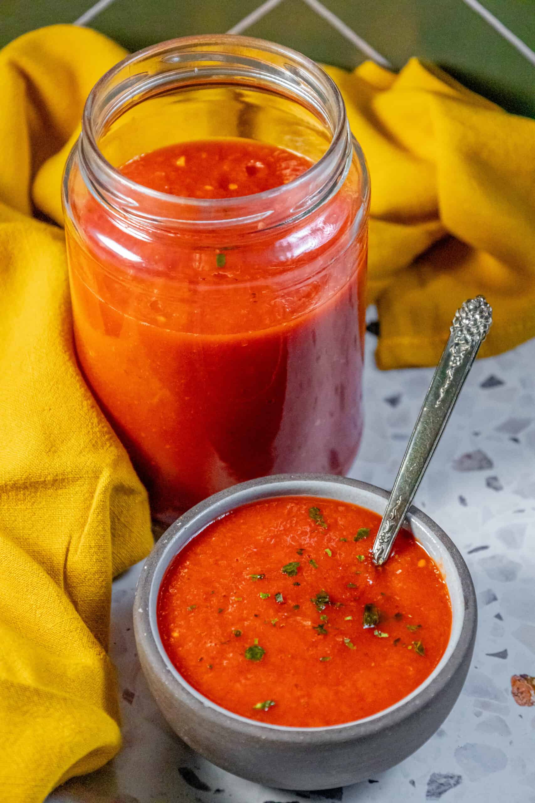 A jar of Margherita tomato sauce with a spoon next to it.