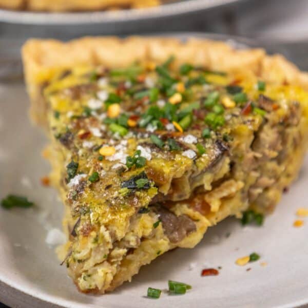 A slice of mushroom quiche on a plate.
