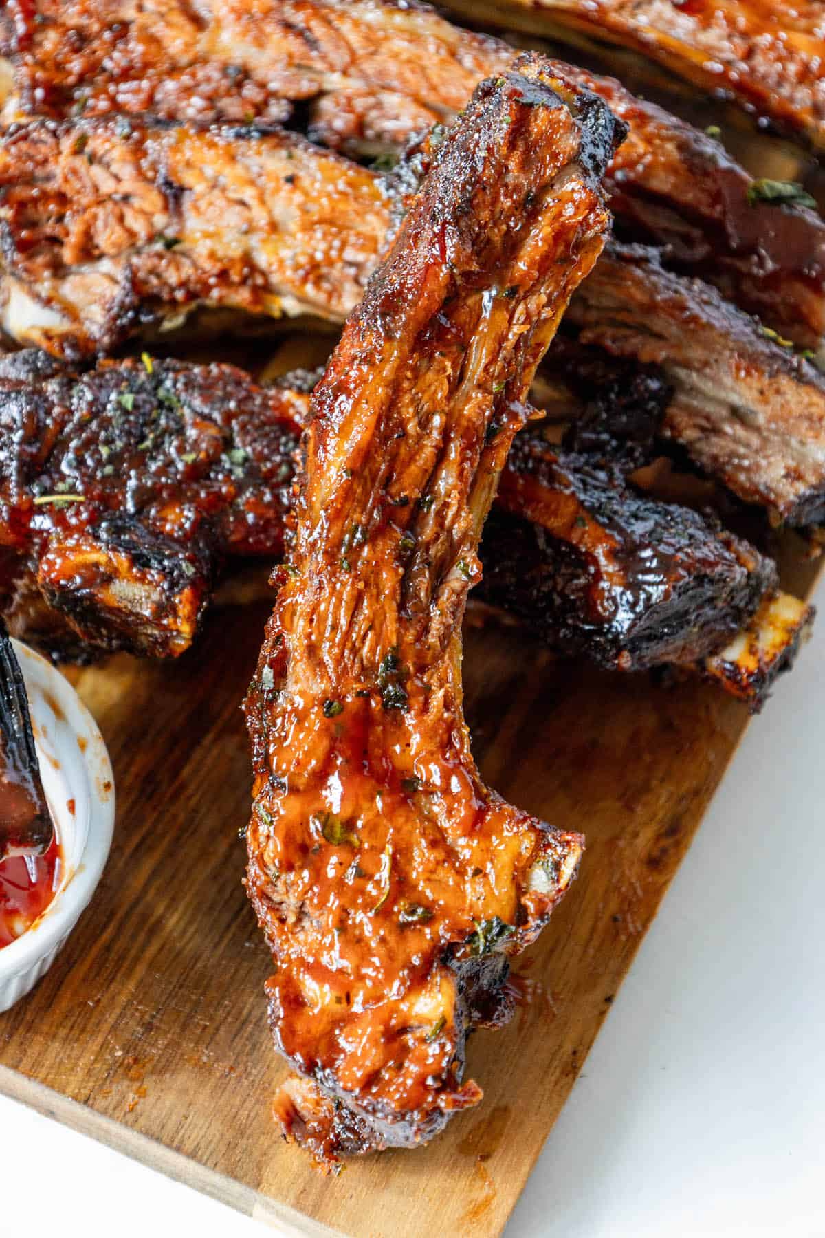 Oven baked bbq ribs on a wooden cutting board.
