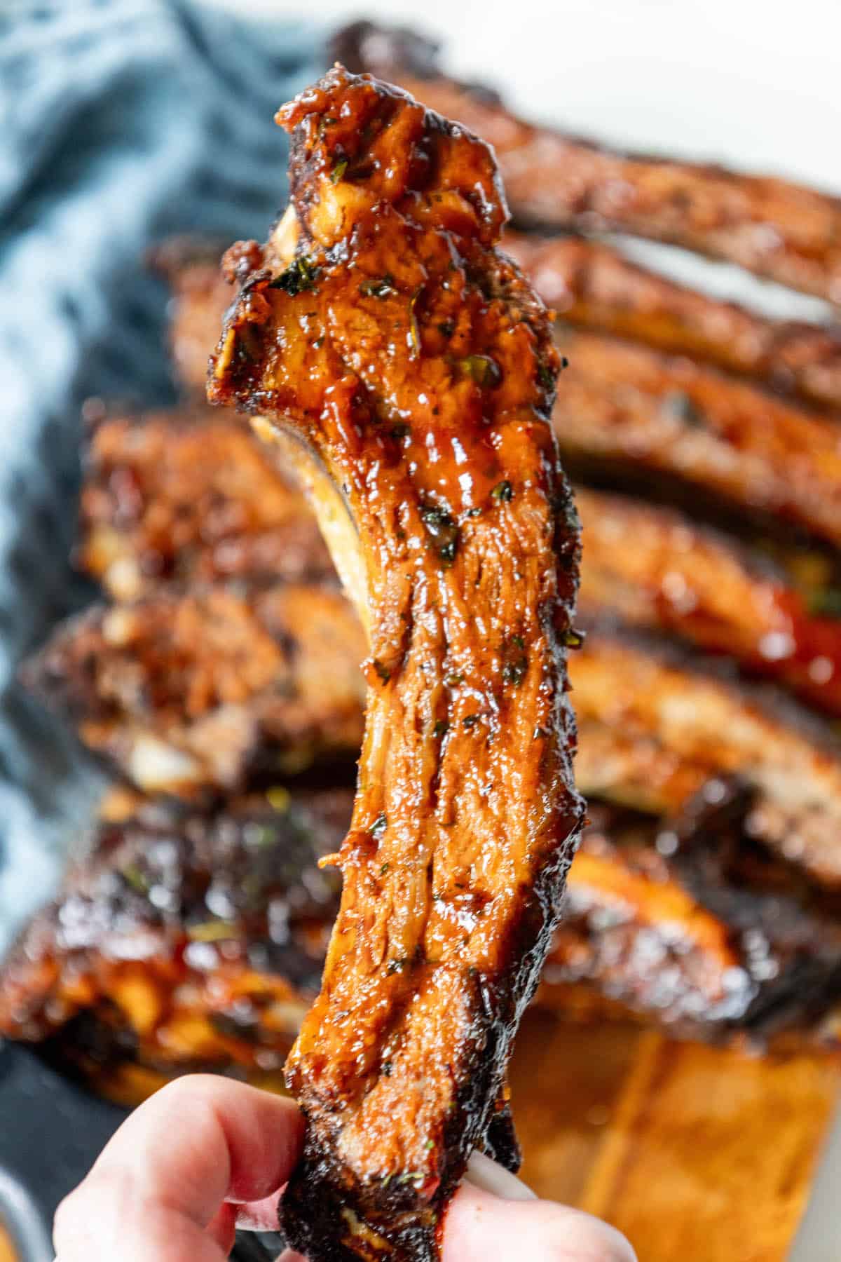 Oven baked bbq beef ribs on a cutting board.