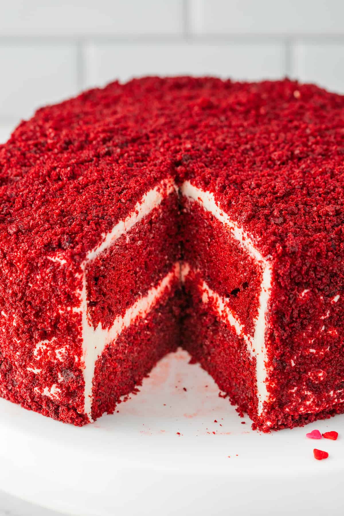 A red velvet cake, perfectly baked with a delightful slice taken out.