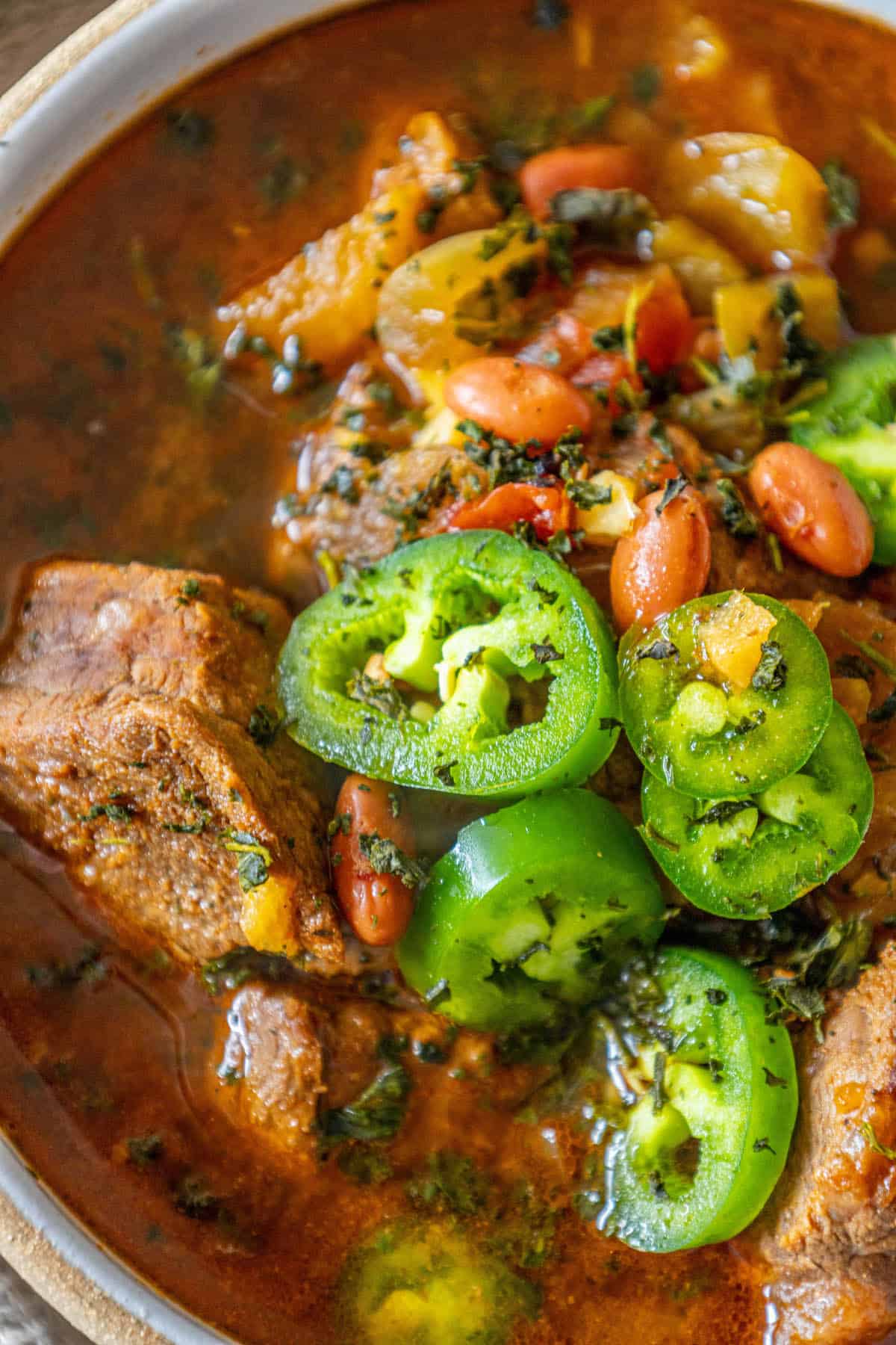 A spicy bowl of beef stew with peppers.