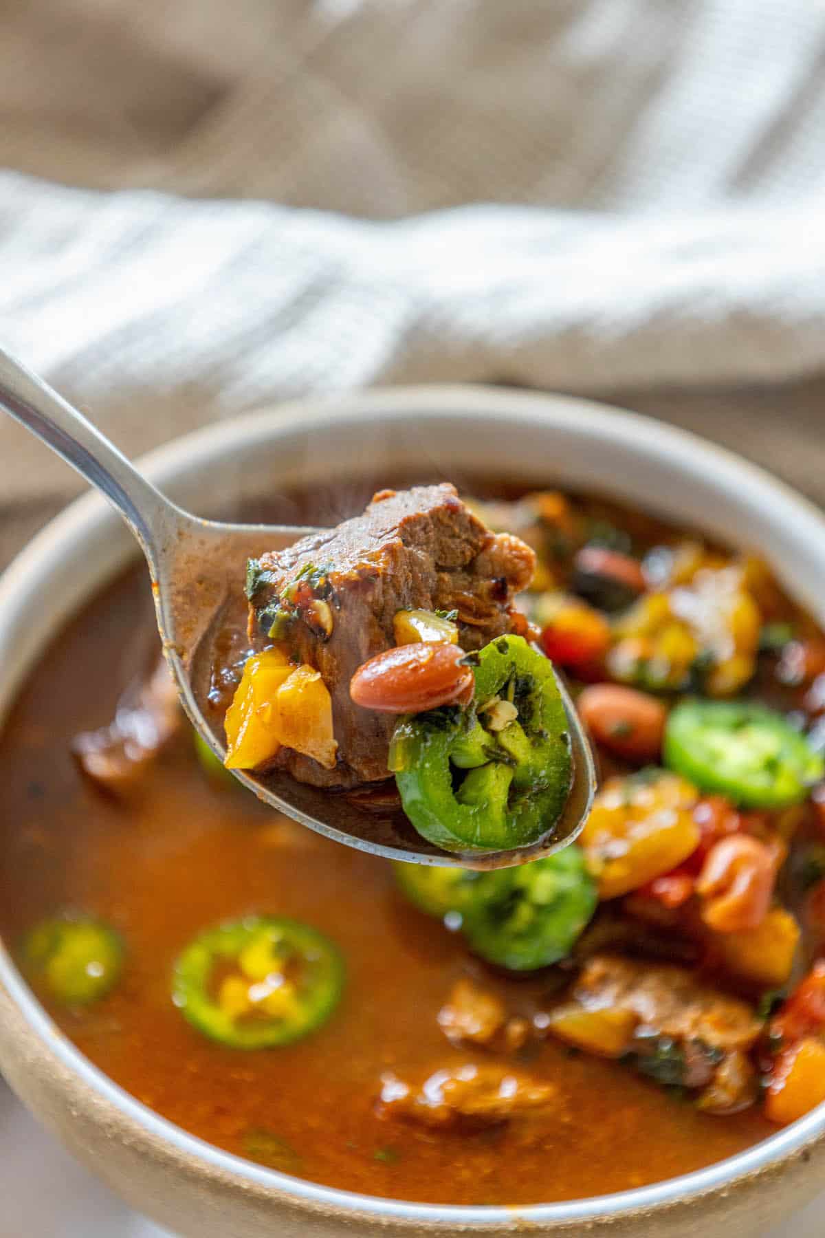 A spicy spoonful of beef and bean soup with jalapenos.