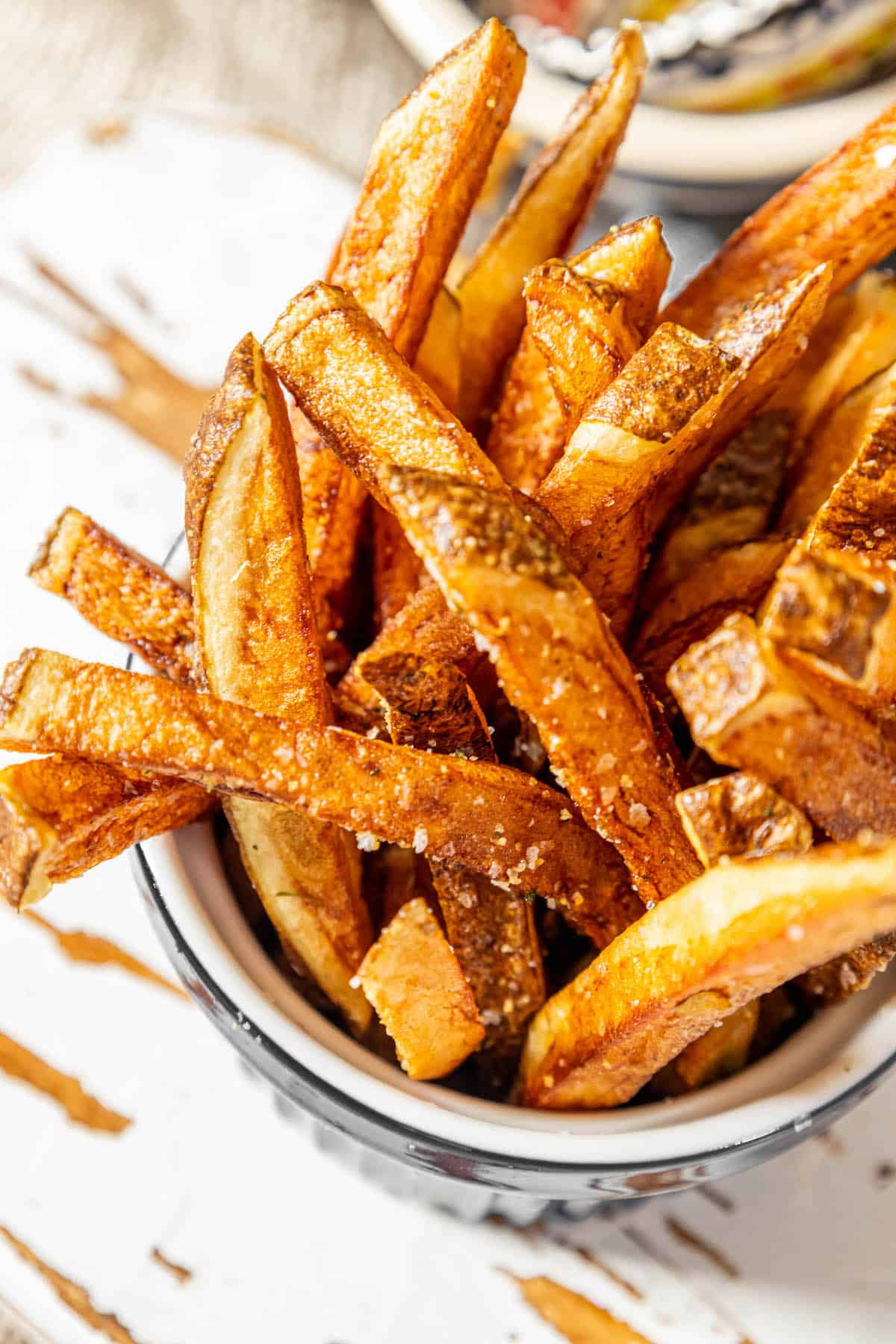 Crispy sweet potato fries served in a bowl on a table.