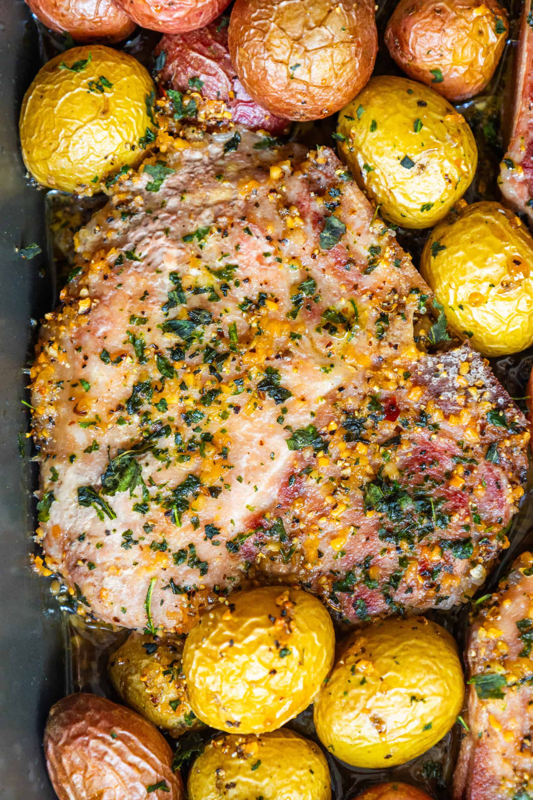 Pork chops and potatoes in a baking dish. This mouthwatering dish combines tender pork chops with golden-brown potatoes, creating a satisfying and hearty dinner option. The pork chops are beautifully seasoned and