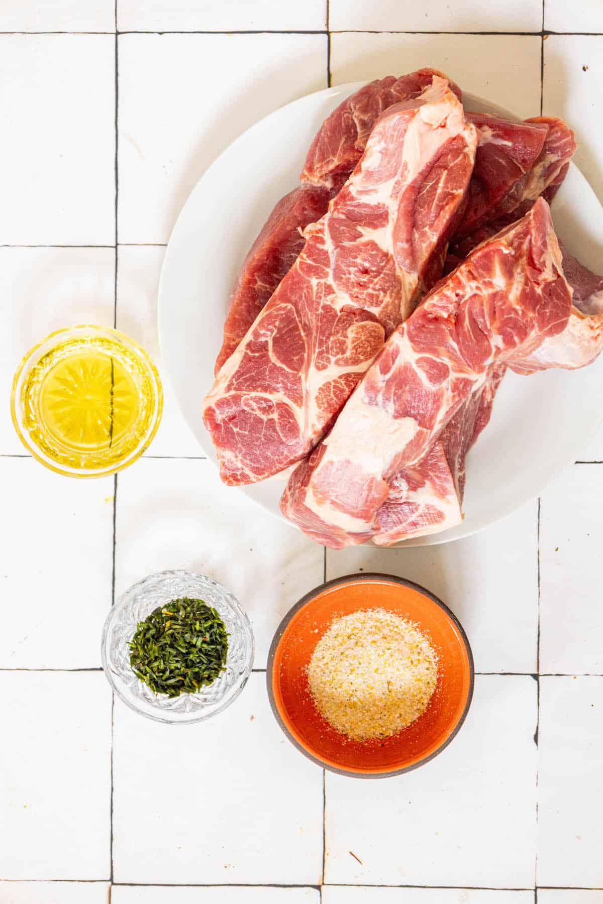 A plate of country-style boneless BBQ meat and spices on a tiled floor.