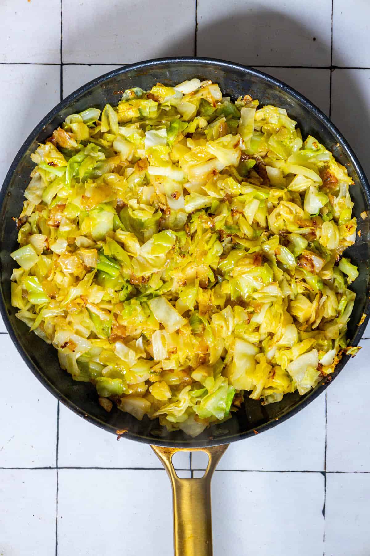 A keto-friendly frying pan filled with cabbage and onions.