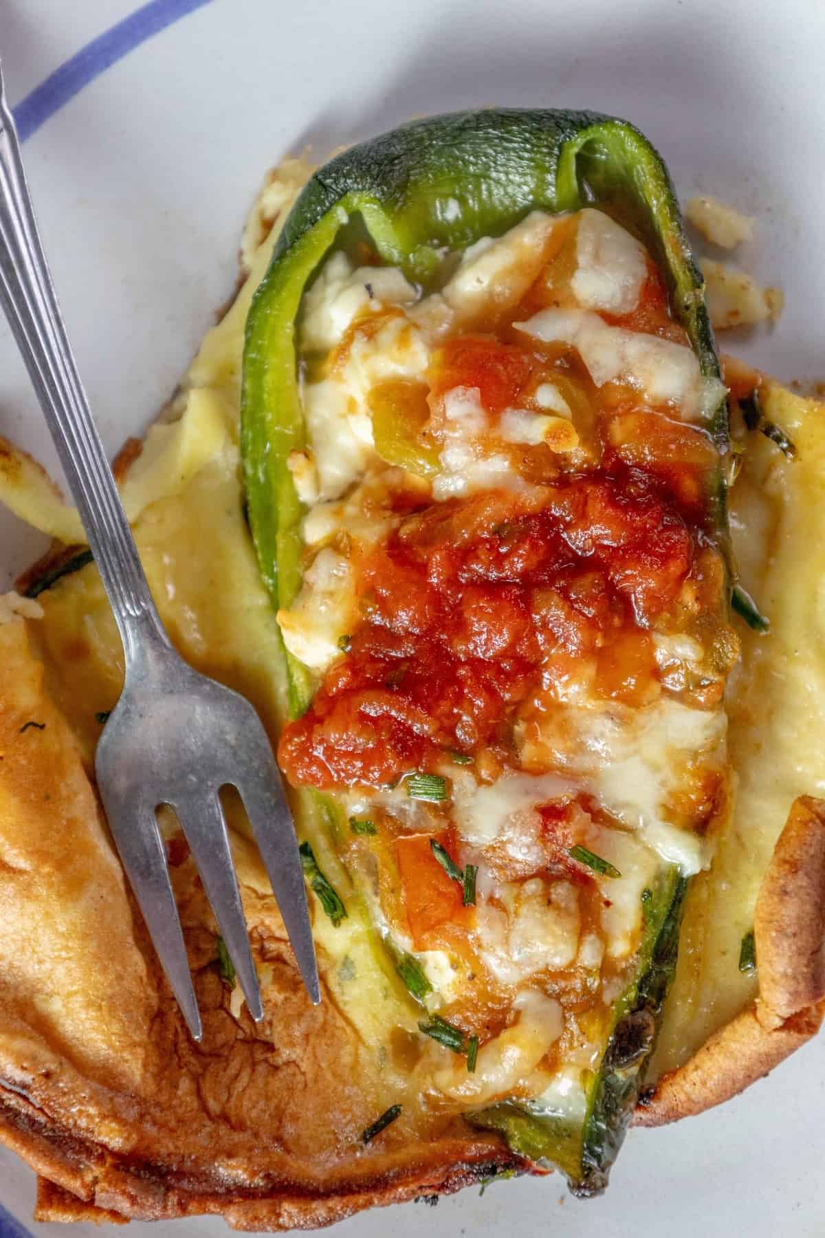 Skillet-baked Chile Rellenos on a plate with a fork.