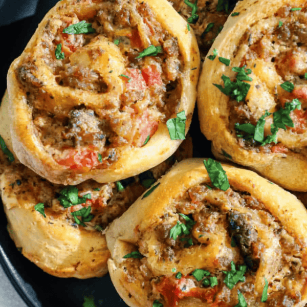 Cheesy mushroom and tomato rolls on a plate.
