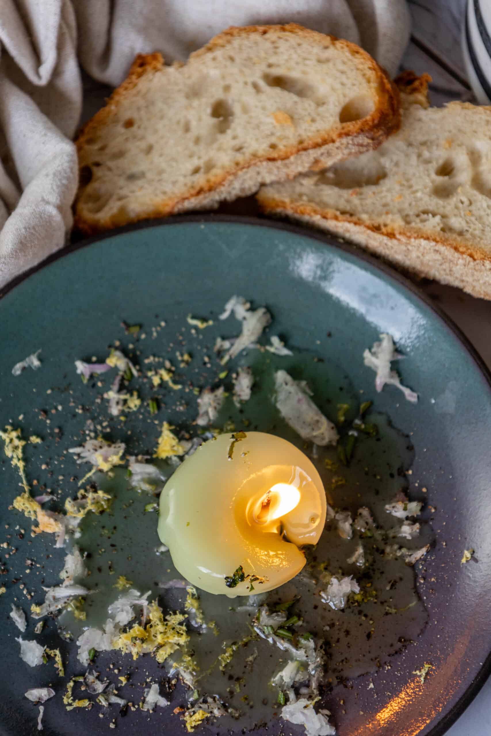 A plate of bread with a Tallow Candle on it.