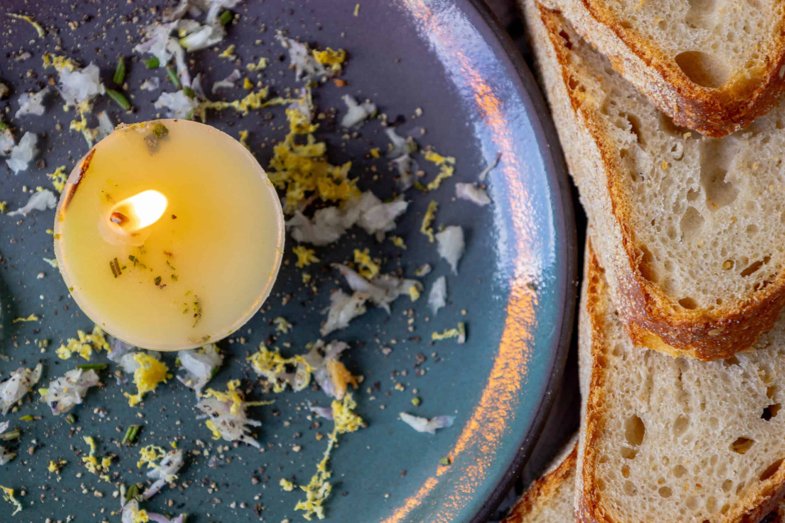 A plate of bread with a tallow candle on it.
