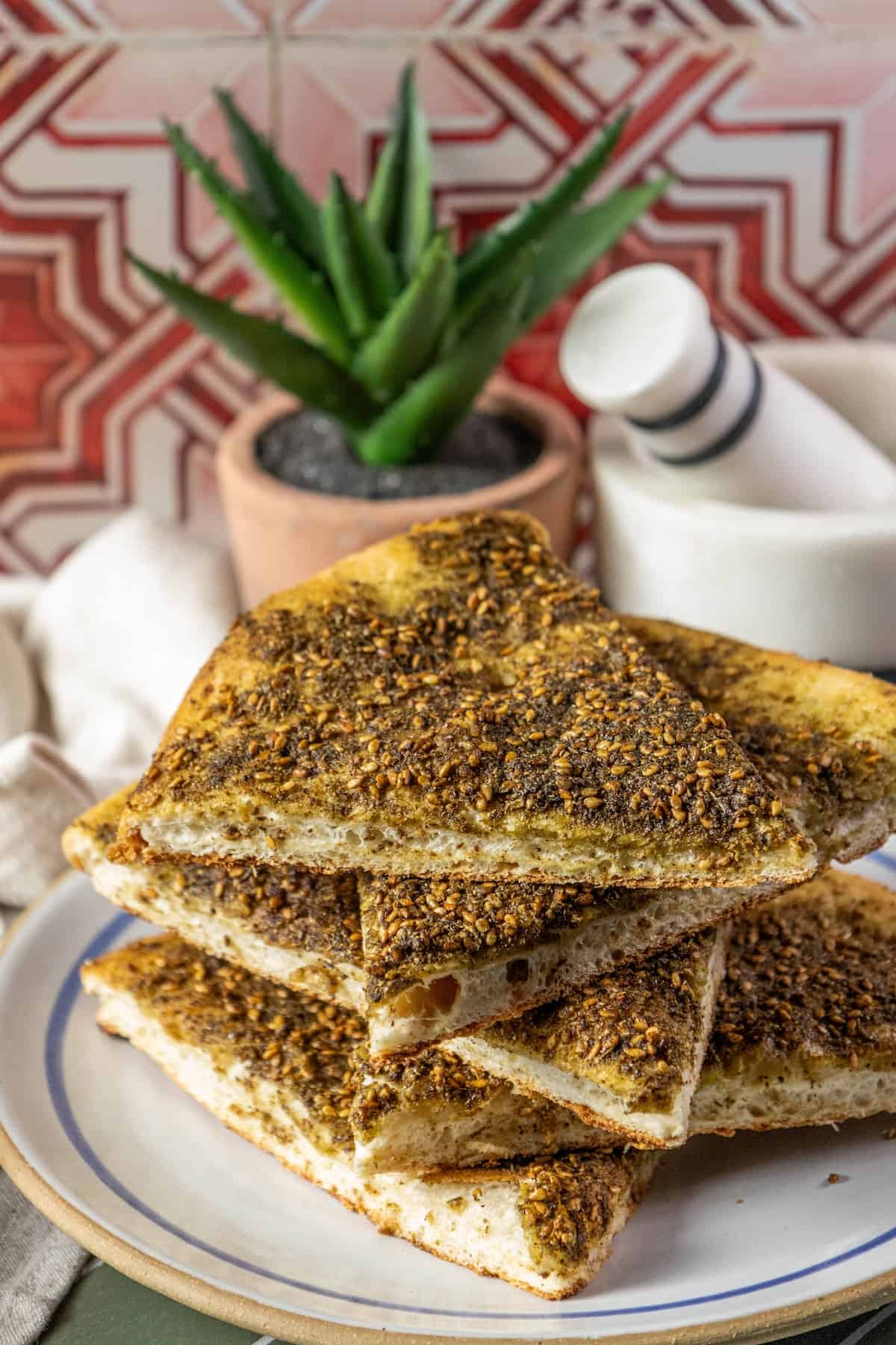 A plate with a stack of flatbreads topped with Za'Atar.