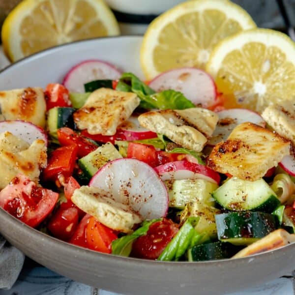 A bowl of Fattoush Salad with tomatoes, cucumbers and radishes.