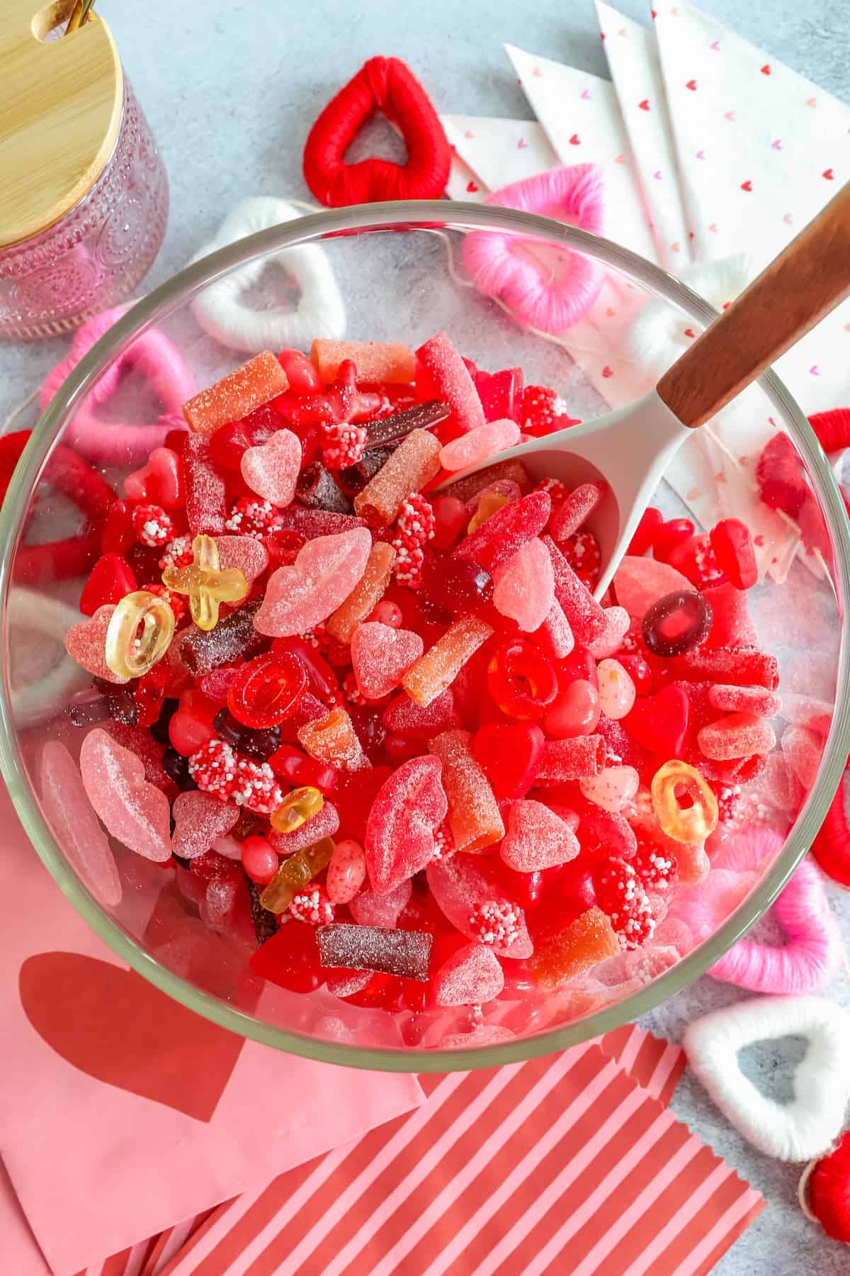Valentine's day candy in a bowl with a wooden spoon.