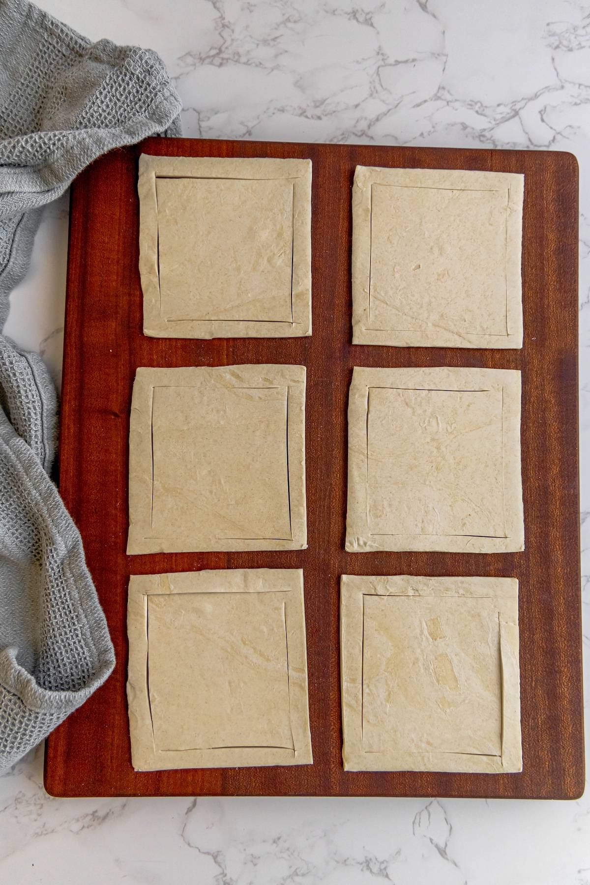 Four squares of dough on a cutting board.