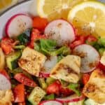 A bowl of Fattoush salad with tomatoes, cucumbers, and radishes.