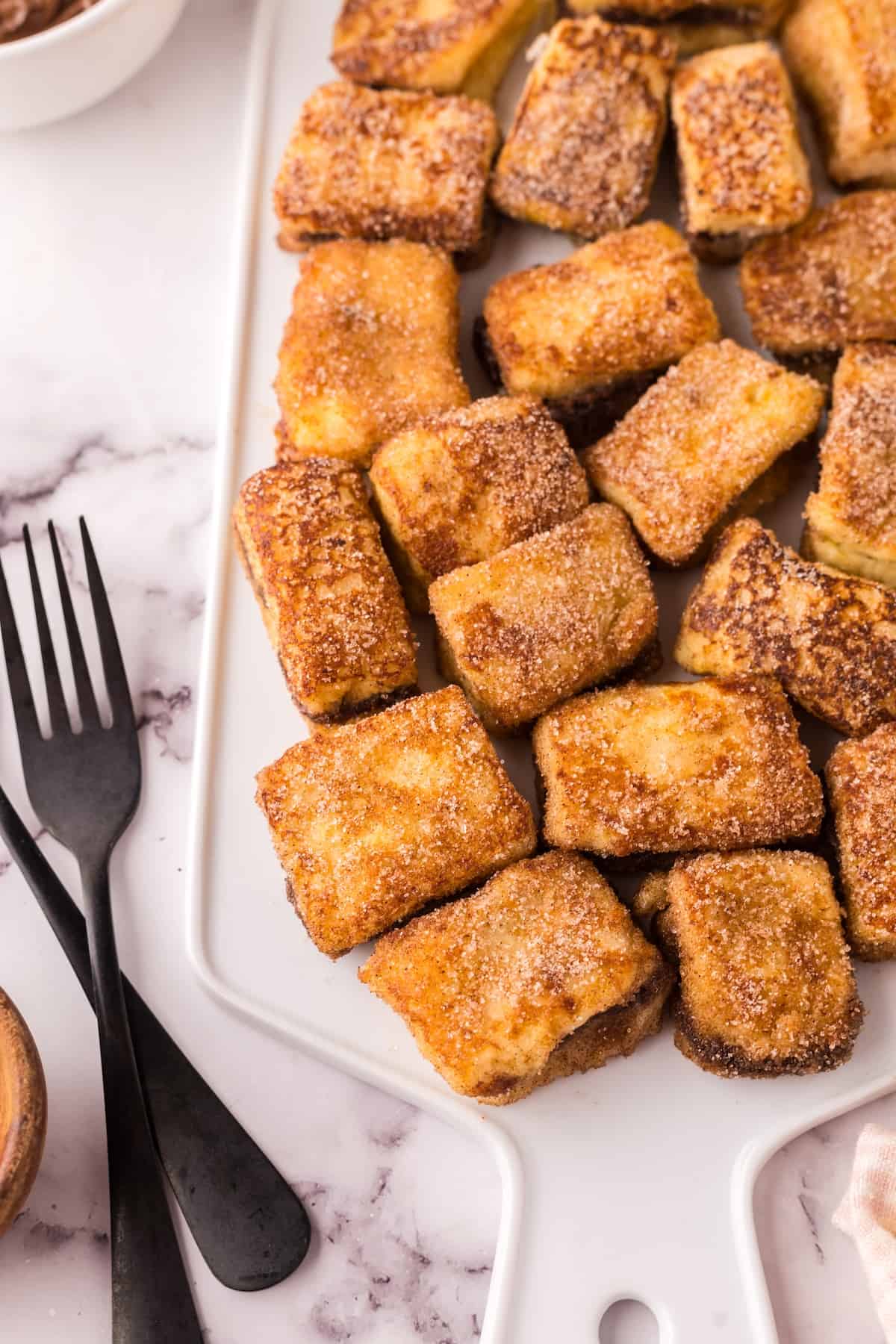 A plate of Stuffed French Toast bites on a marble surface.