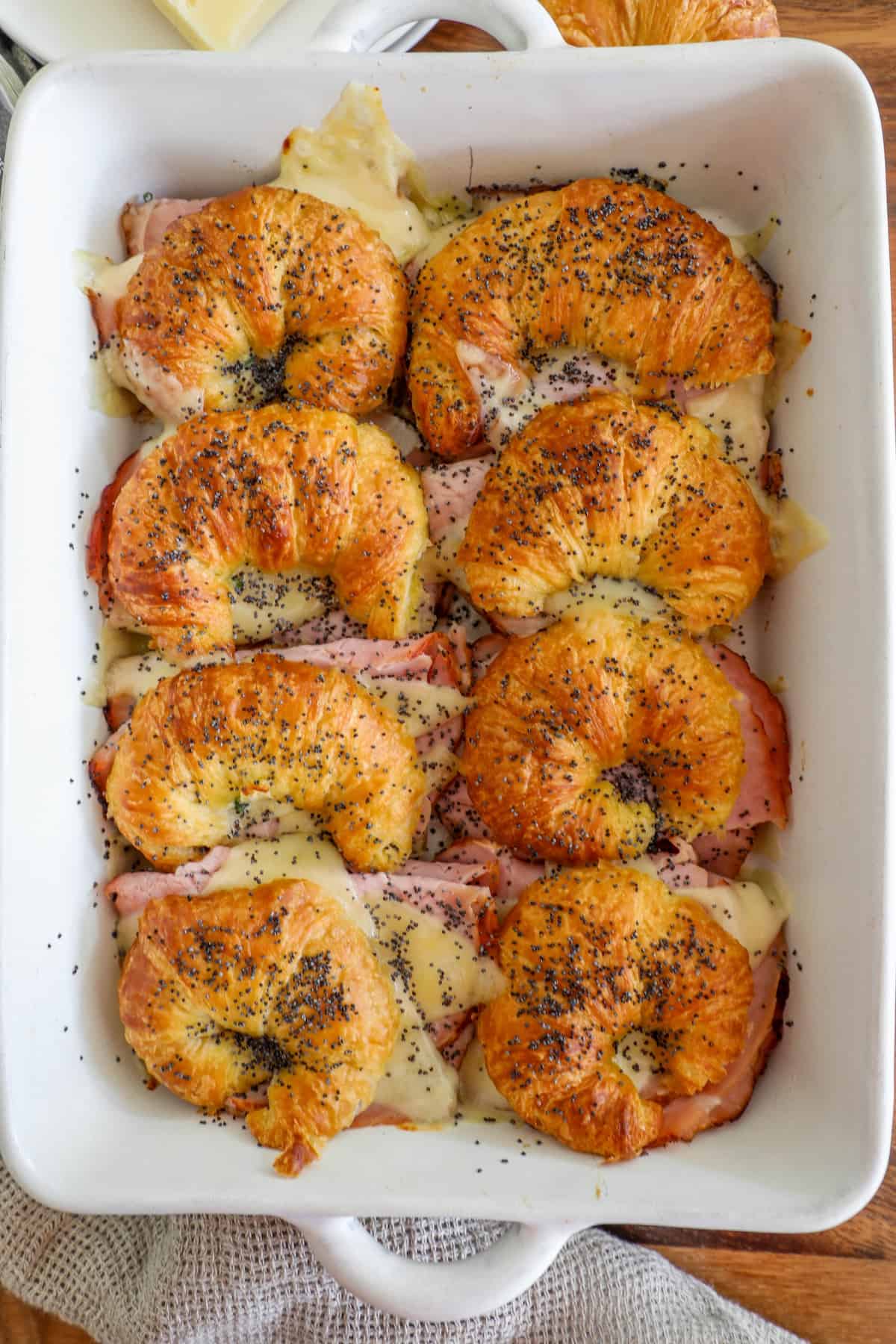 Ham and cheese croissants in a baking dish.