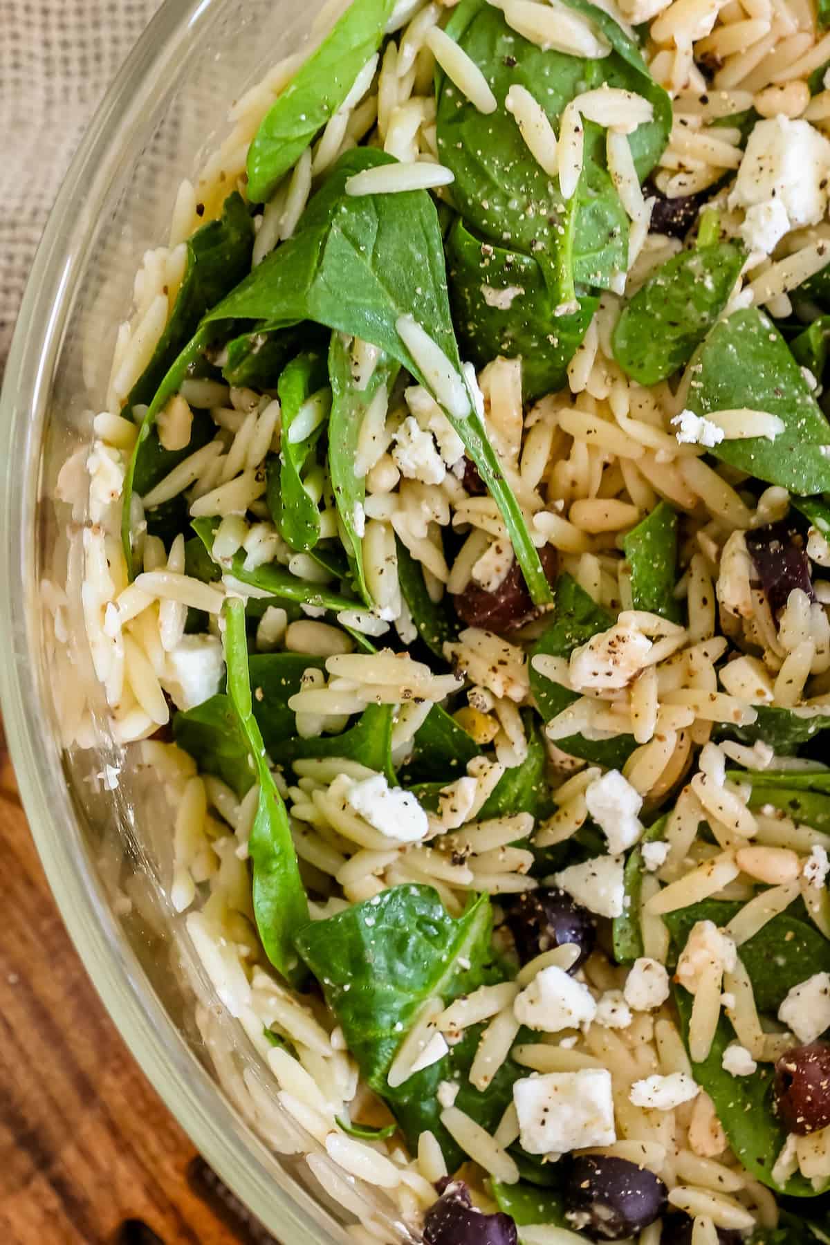 A bowl of spinach and feta salad with orzo.
