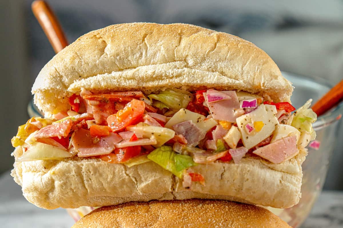 An Italian sandwich filled with ham and coleslaw.