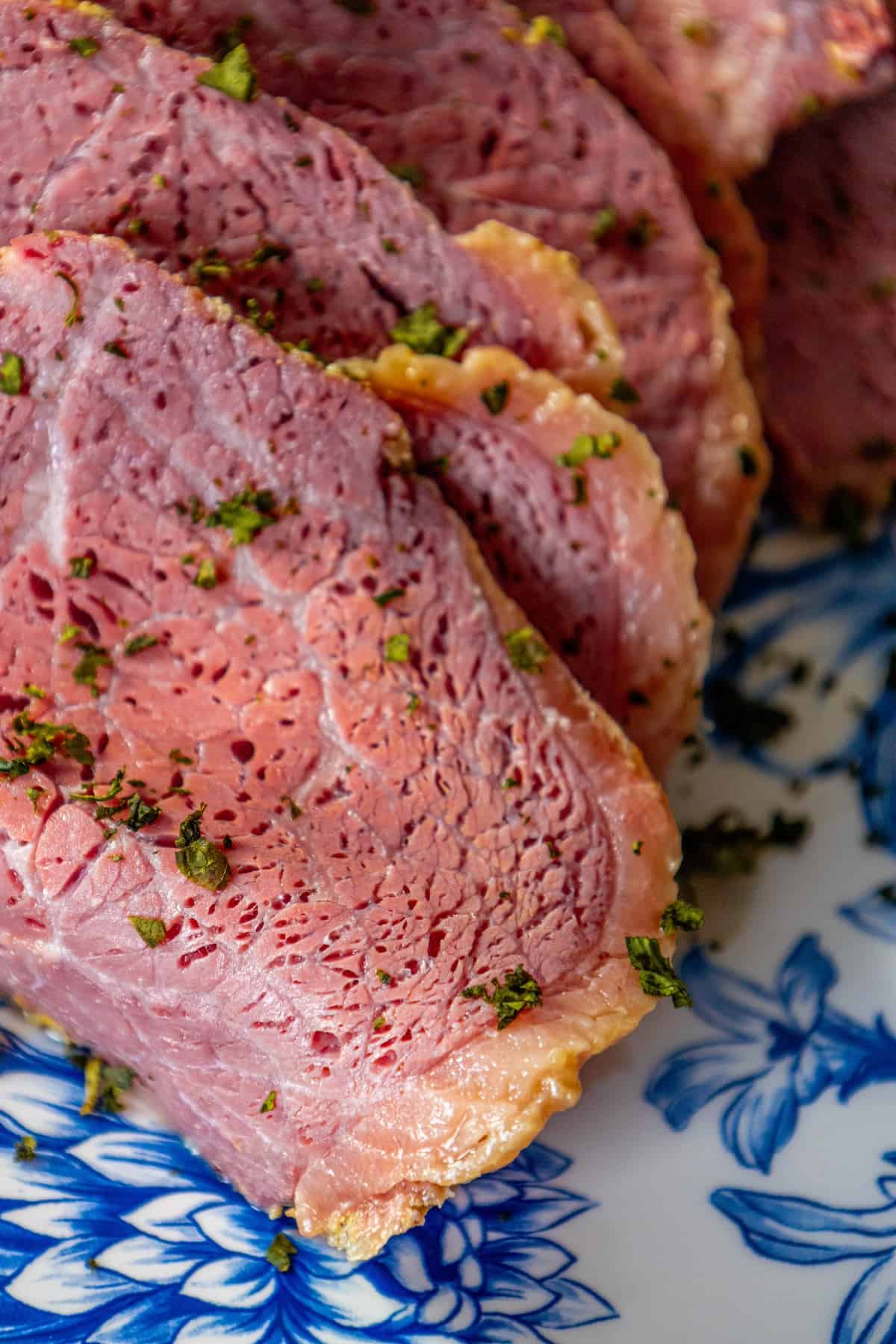 Sliced corned beef on a blue plate.