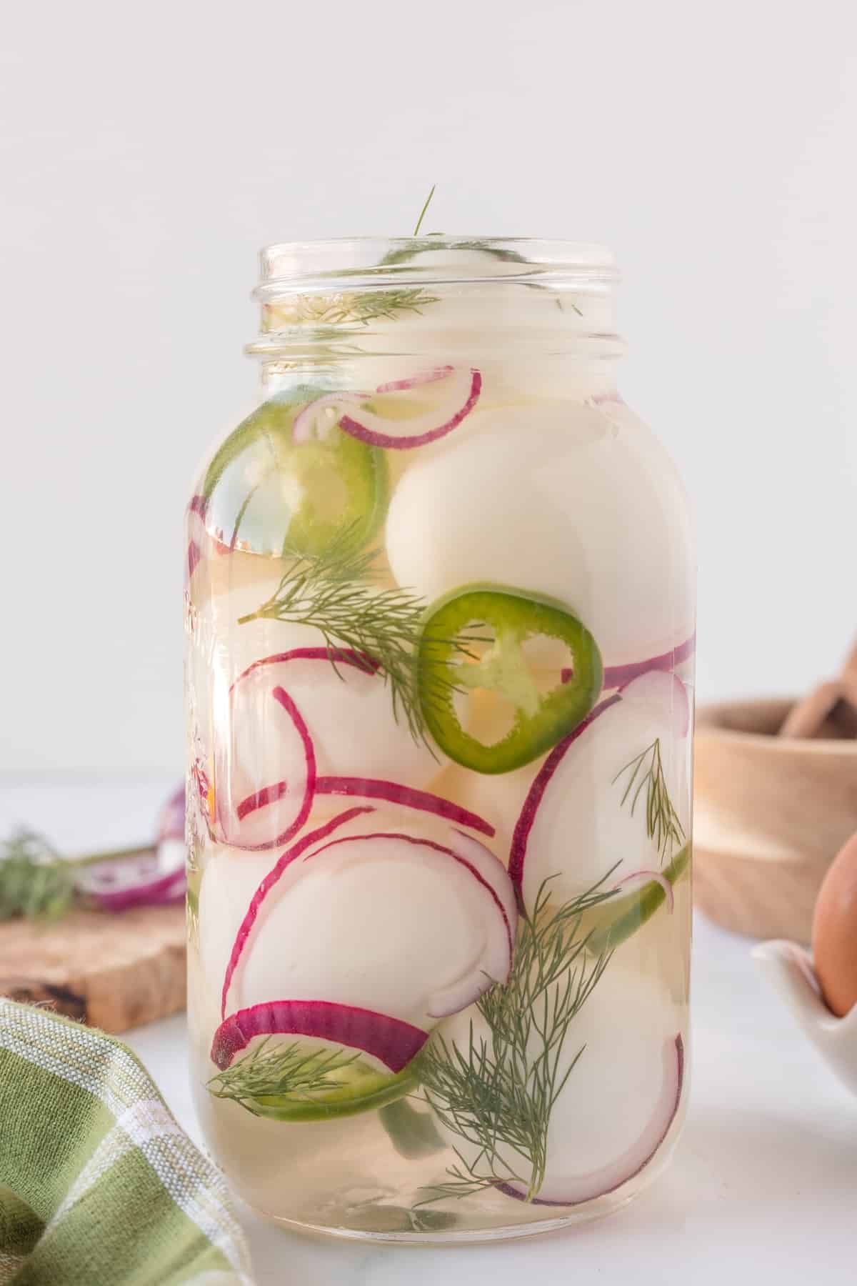 A mason jar filled with spicy pickled eggs.