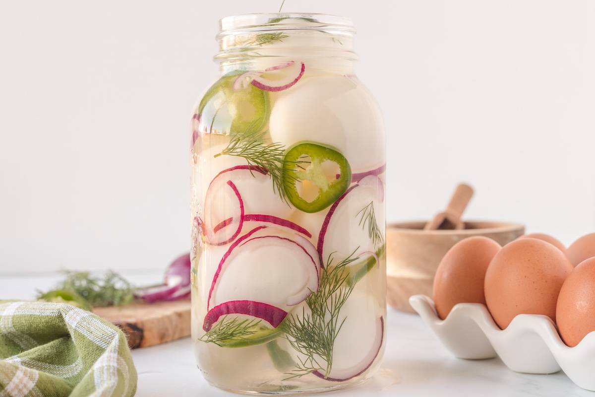 A spicy mason jar filled with pickled eggs and radishes.