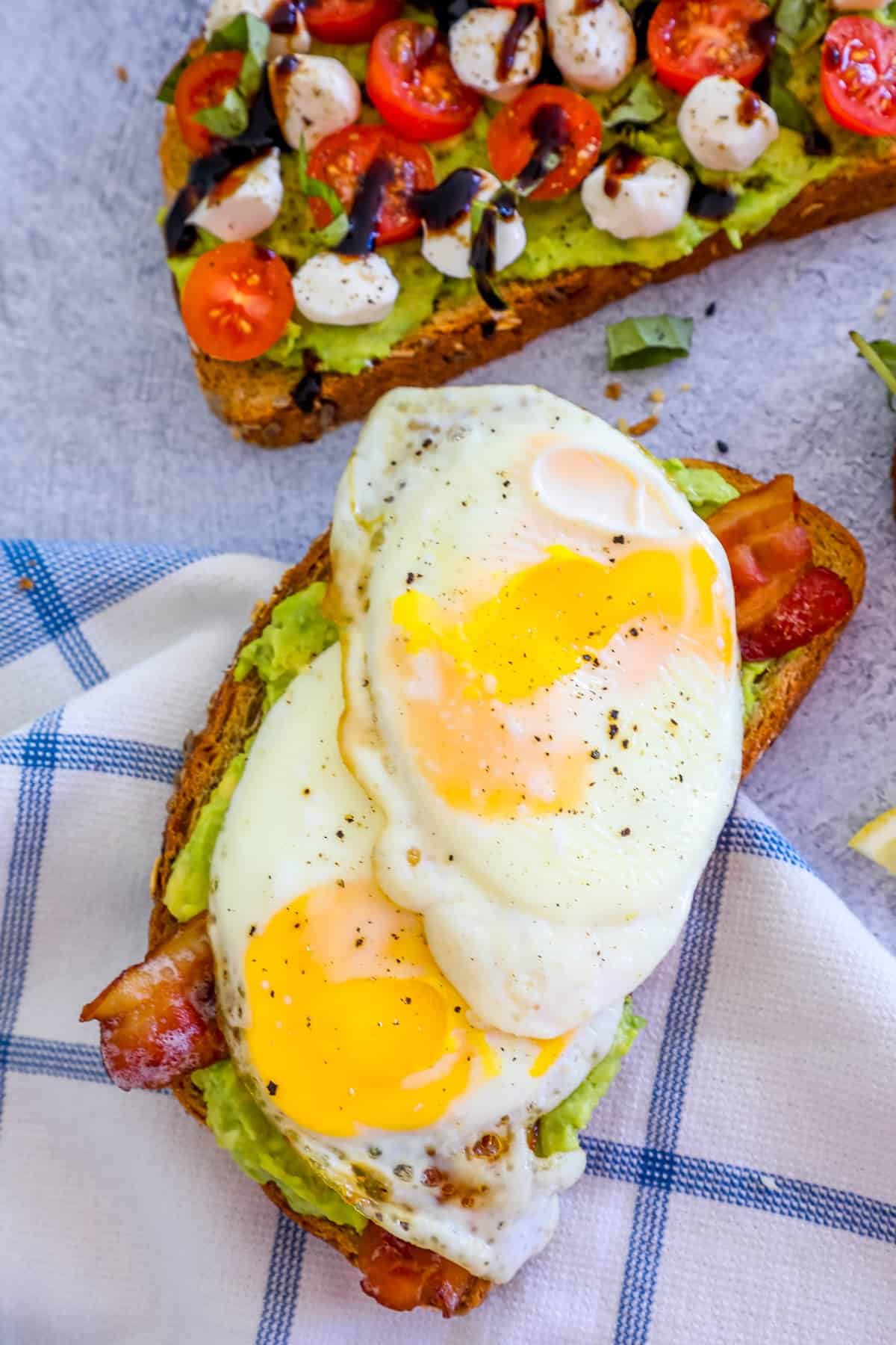 A toast with eggs, tomatoes and avocado on it.