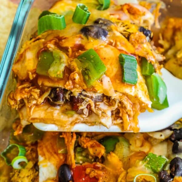 A serving of layered chicken taco casserole with green bell peppers on top.