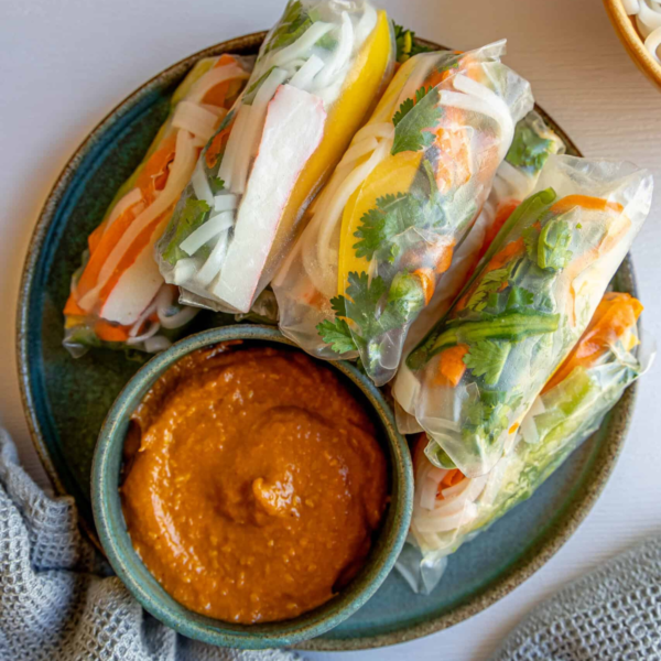 Plate of Vietnamese crab spring rolls served with dipping sauce.