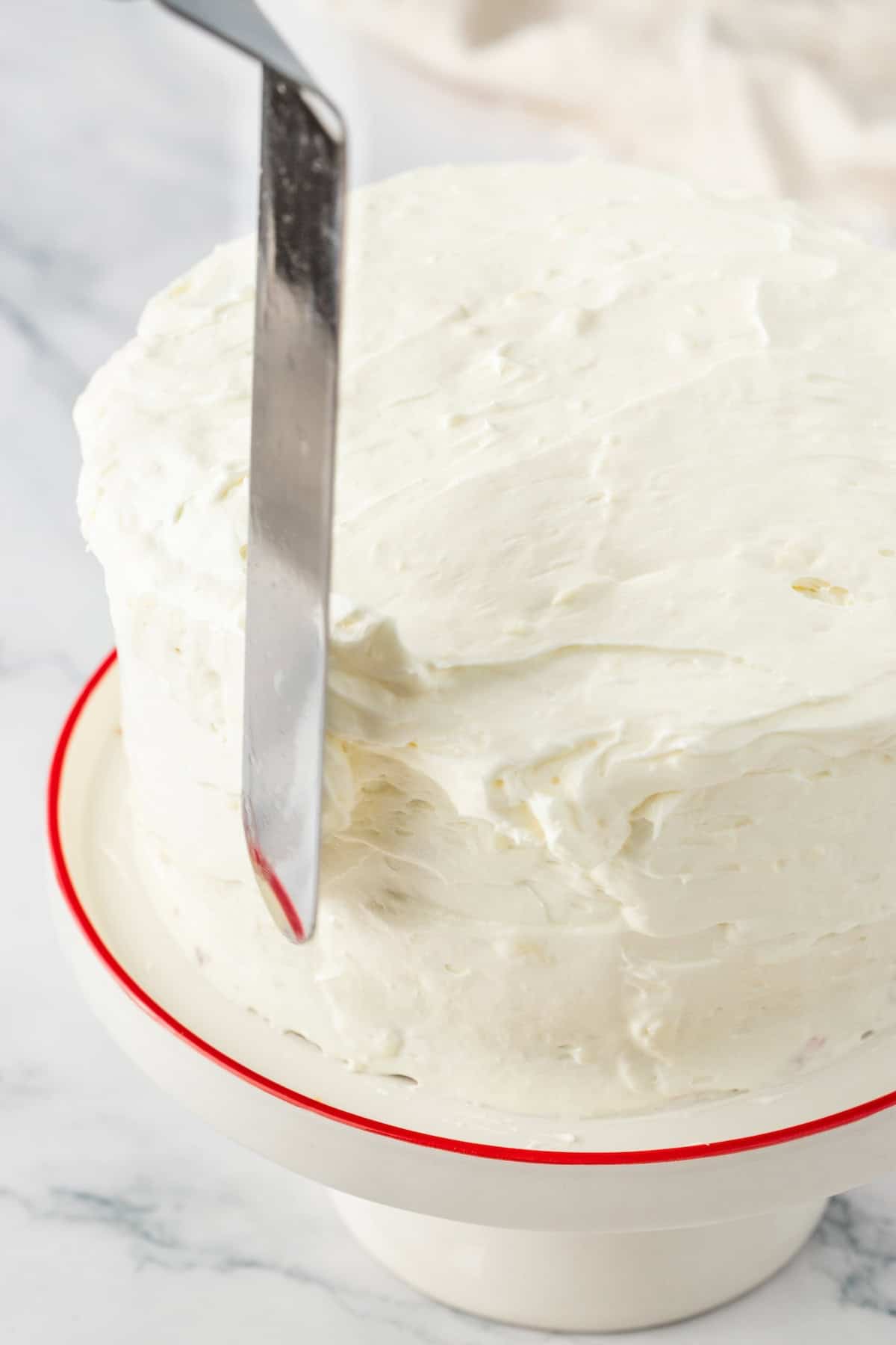 cake being iced with a spatula