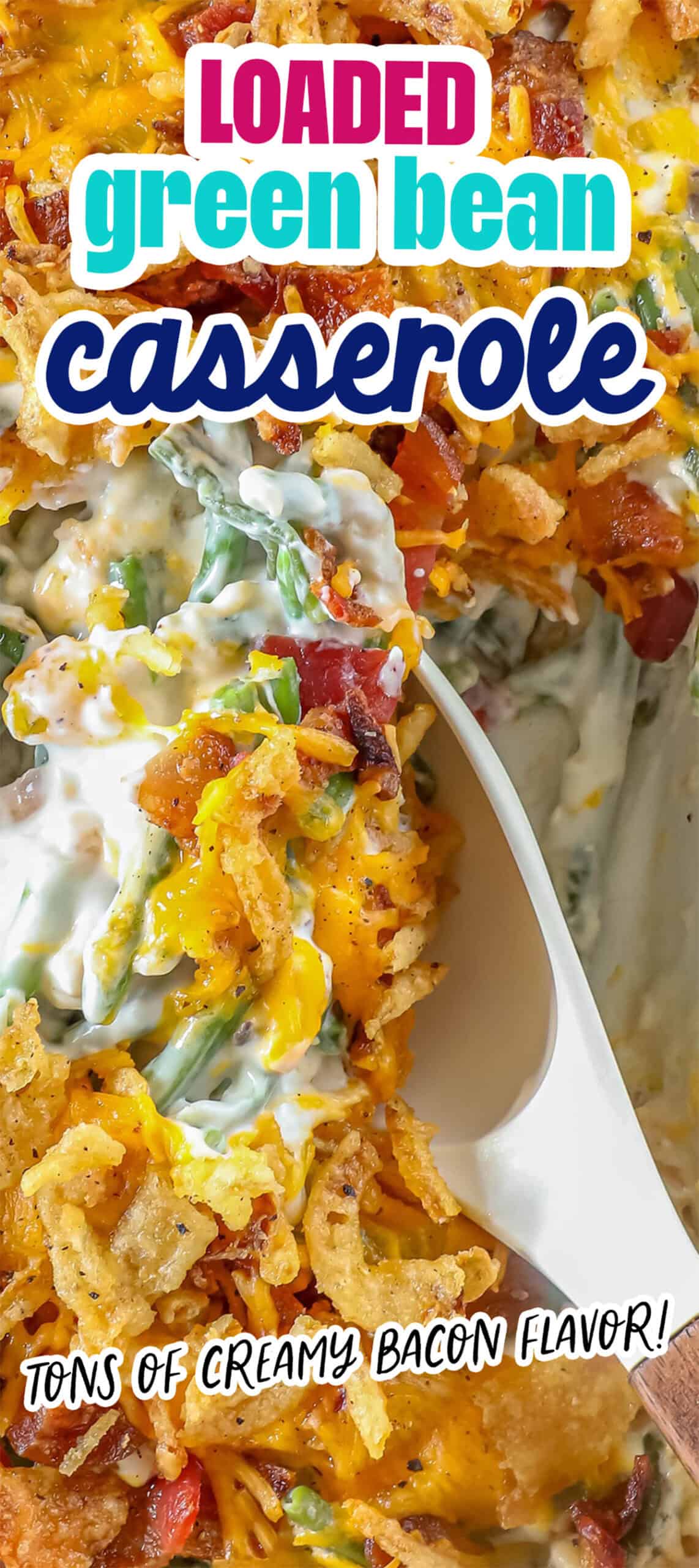 A close-up of a delectable green bean casserole reveals creamy sauce, bacon, cheese, and crispy fried onions as a spoon scoops from the dish.